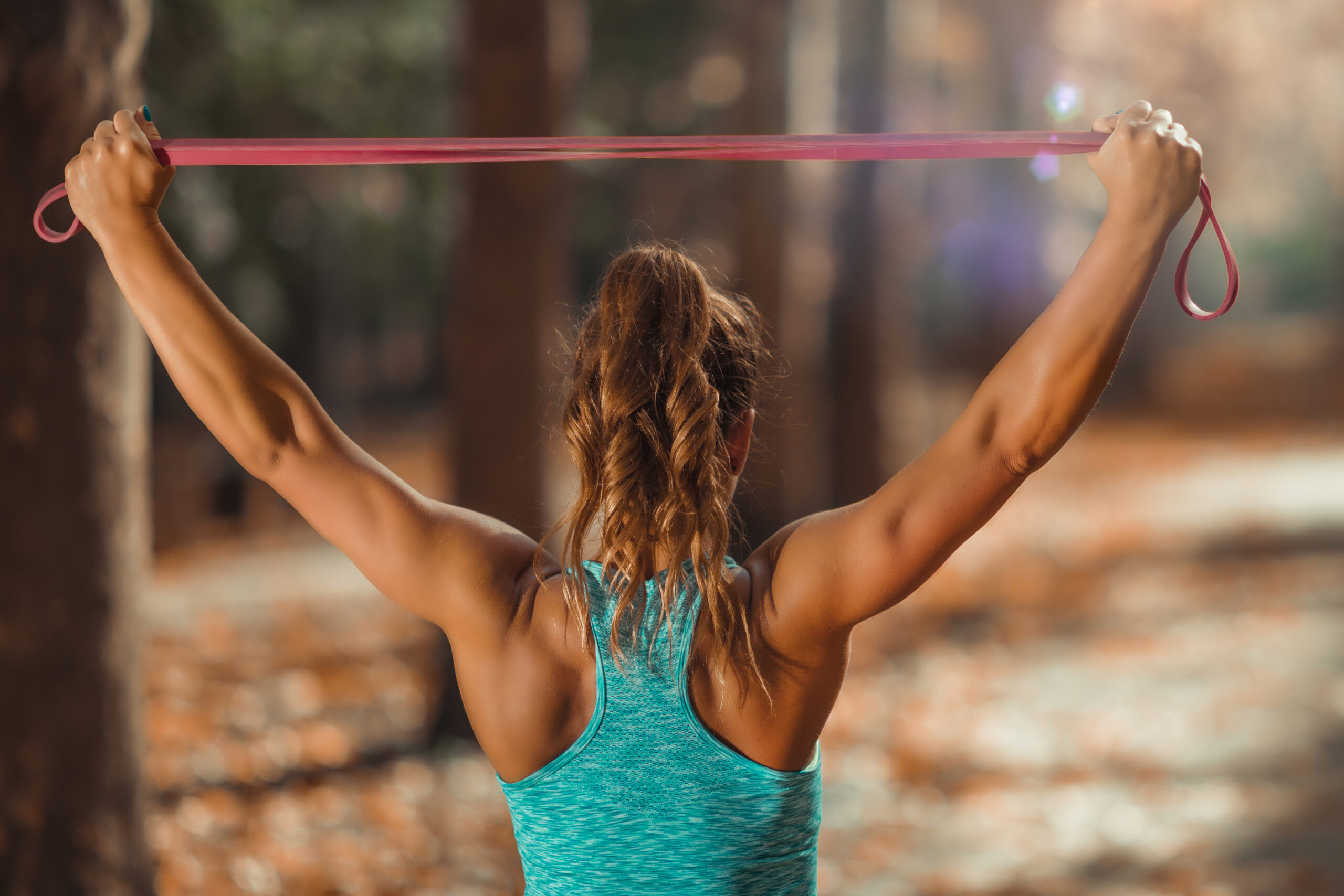 Woman Working out With Elastic Band Outdoors in The Fall, in Public Park