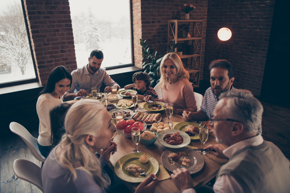 Close up photo big large family thanksgiving conversation members company brother sister granny mom dad grandpa son daughter sitting round festive holiday full tasty dishes table loft house indoors