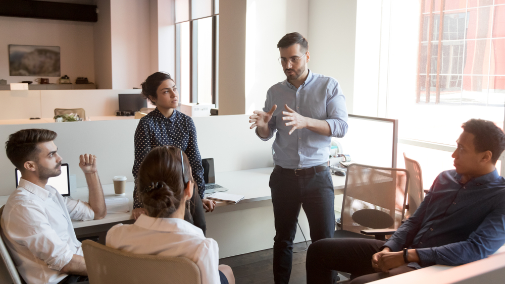 Fasting for productivity and leadership.Serious business man team leader coach mentor talk to diverse business people in office explain strategy at corporate group meeting, multiethnic staff listen to boss instruct interns at briefing