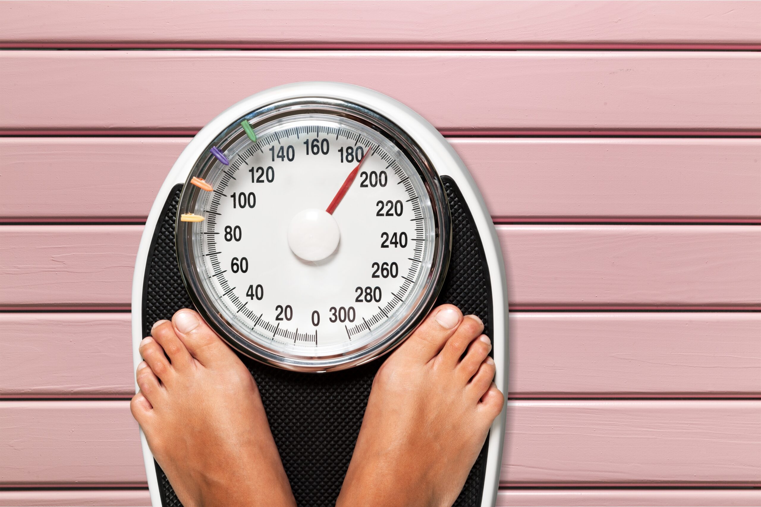 Woman on weight scale managing obesity