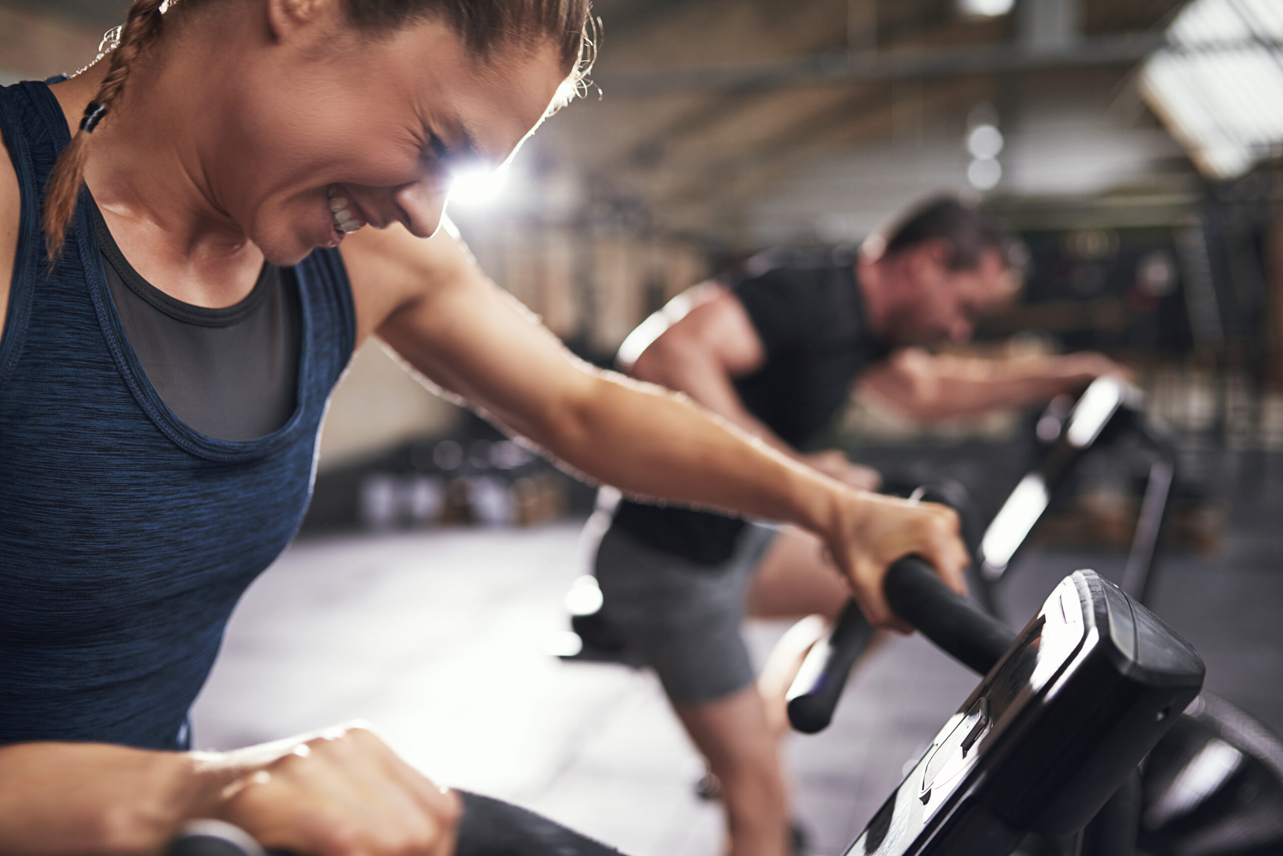 Hard working sportive people doing cardio on exercycle. Horizontal indoors shot