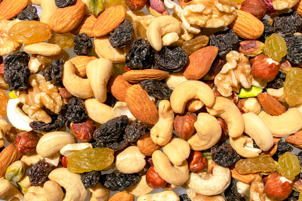 Background made of mixed nuts and raisins. Healthy snack and food. Cashew, almond, raisins, walnut, pistachio. Top view. Assorted nuts and dry grapes.