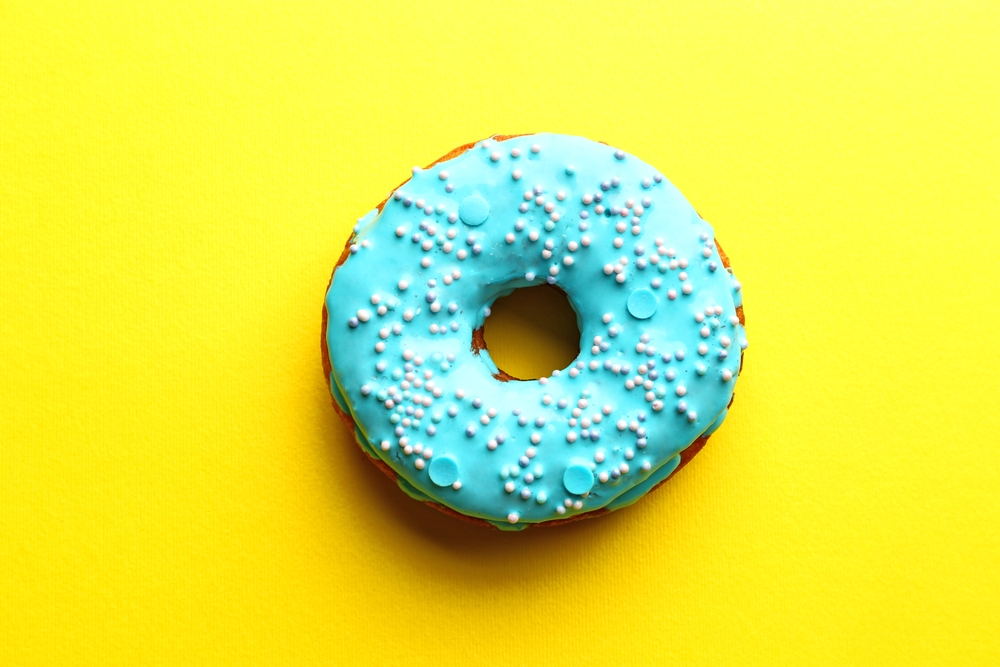 snacking can damage health Tasty glazed donut on color background
