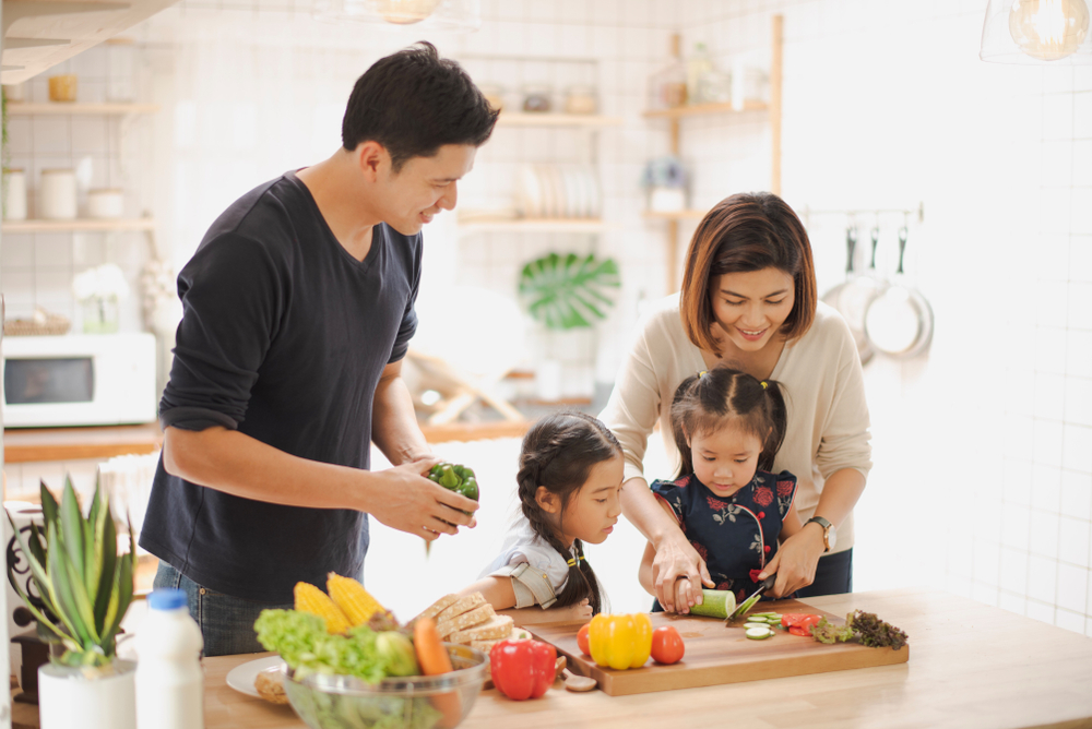 lifestyle medicines Young Asian love family are preparing the breakfast, sandwich vegetable on table in the kitchen which Excited smiling and felling happy. parent teach daughter to cooking food on the day at home.