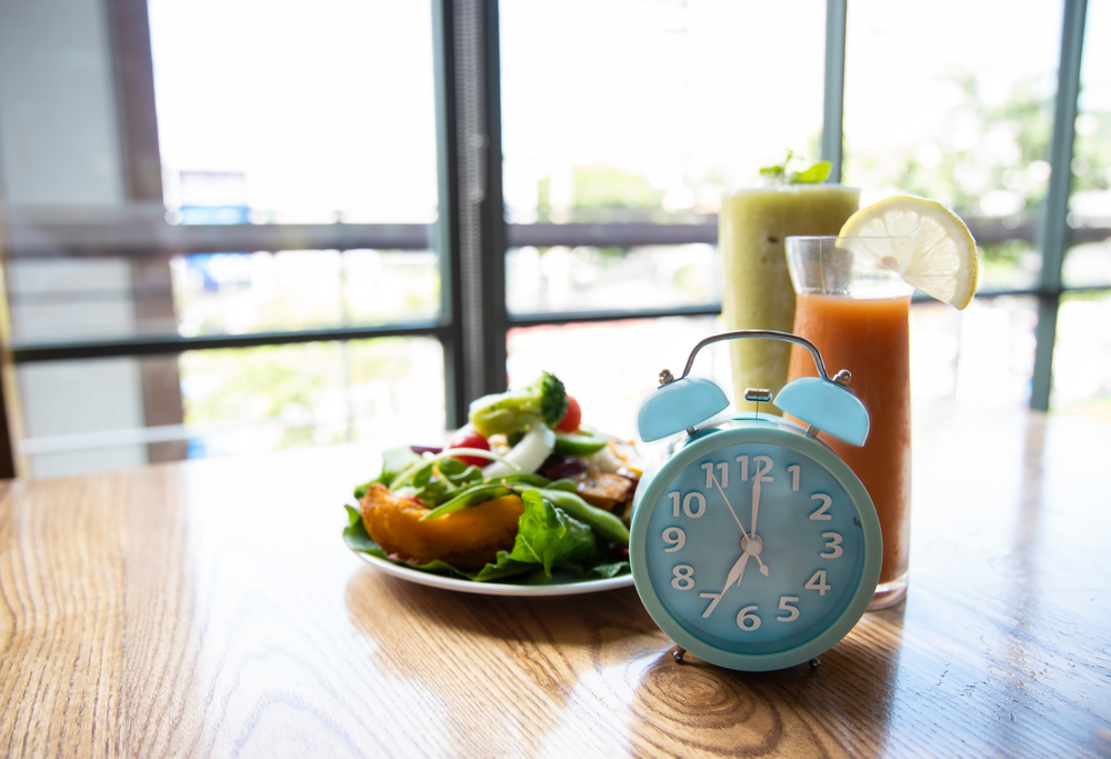 how to choose a fasting window Selective focus of blue clock intermittent fasting image as window background,ketogenic diet, weight loss concept