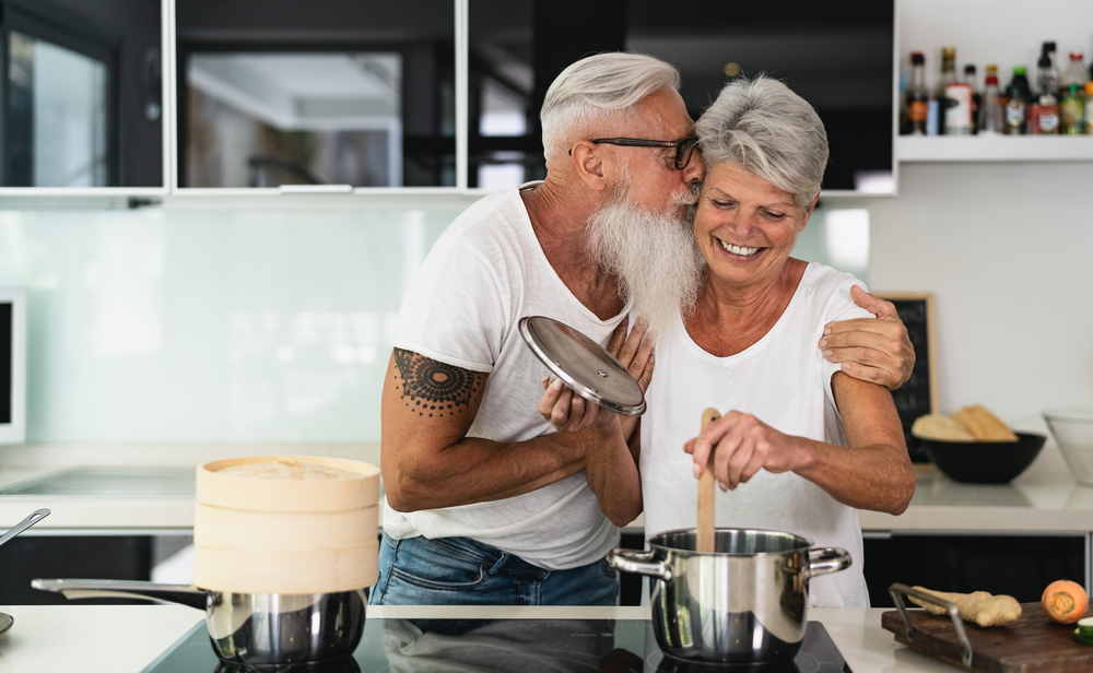 eating for longevity Happy senior couple having fun cooking together at home - Elderly people preparing health lunch in modern kitchen - Retired lifestyle family time and food nutrition